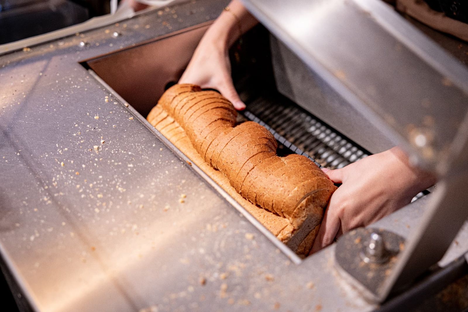 Vers brood gaat door de snijmachine in de winkel in Wernhout